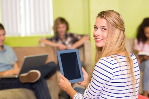 Mujer joven casual con tableta digital en la oficina