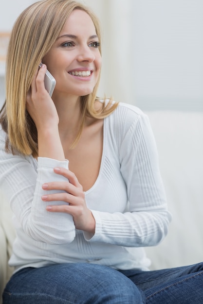 Mujer joven casual usando teléfono móvil en casa