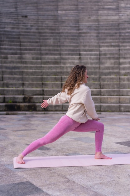 Mujer joven caucásica haciendo fitness en un parque de la ciudad