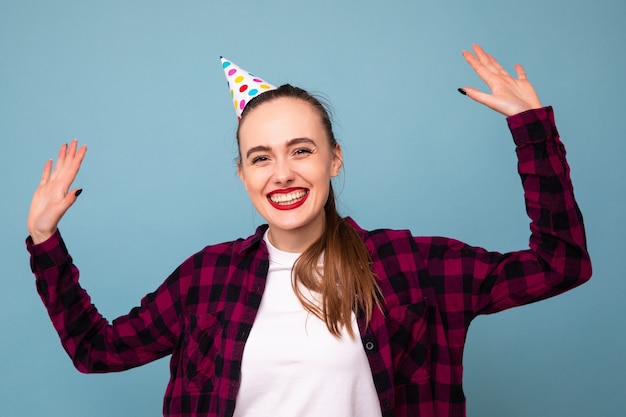 Una mujer joven celebra unas vacaciones con una gorra en la cabeza.