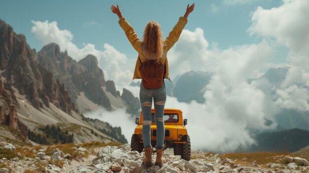 Mujer joven celebrando la libertad por encima de los picos de las montañas nubladas