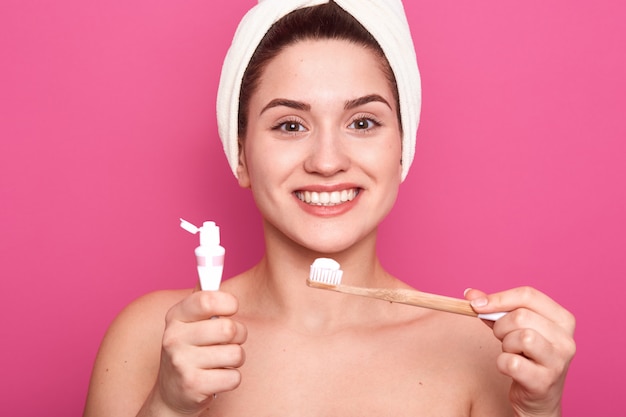 Mujer joven con cepillo y pasta de dientes para la limpieza de los dientes en las manos. feliz niña sonriente con cepillo de dientes