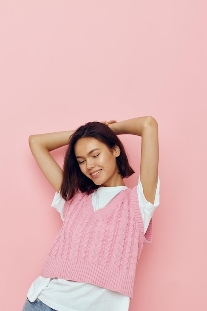 Mujer joven en un chaleco rosa posando ropa casual Estilo de vida inalterado