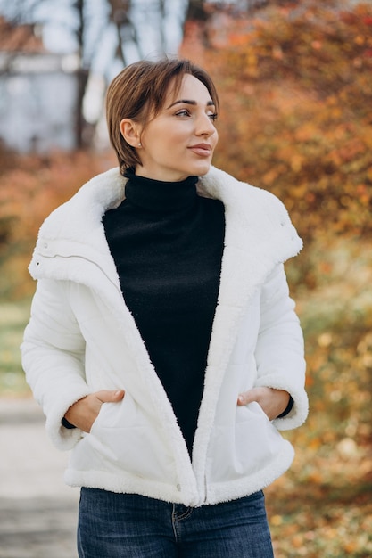 Foto mujer joven, en, chaqueta blanca, aire libre