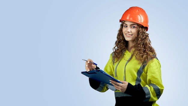 Mujer joven en una chaqueta y casco de construcción