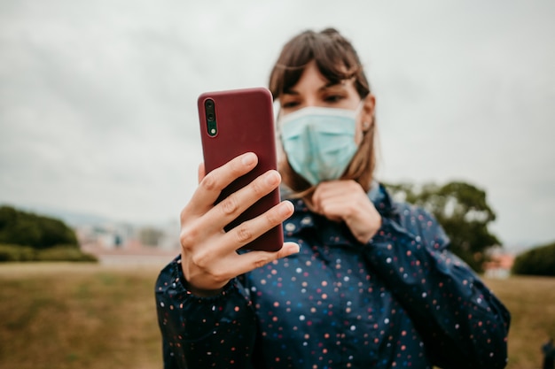 Foto mujer joven en una chaqueta con una máscara médica