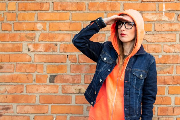 Mujer joven en una chaqueta de mezclilla y gafas