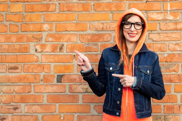 Mujer joven en una chaqueta de mezclilla y gafas