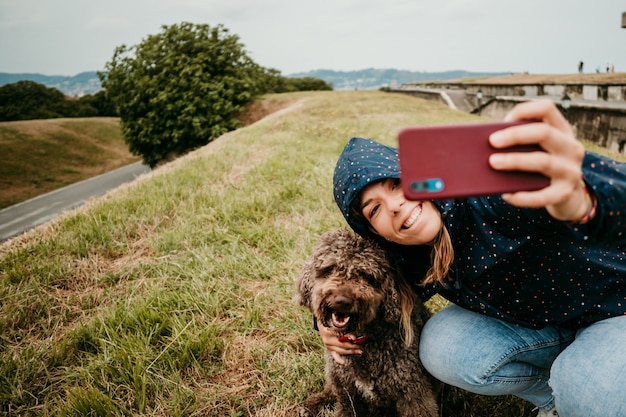 Mujer joven en una chaqueta con un perro