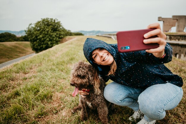 Mujer joven en una chaqueta con un perro