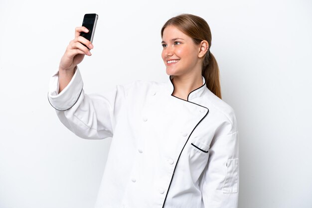 Mujer joven chef aislada sobre fondo blanco haciendo un selfie
