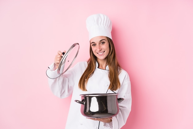 Mujer joven chef caucásico cocinando