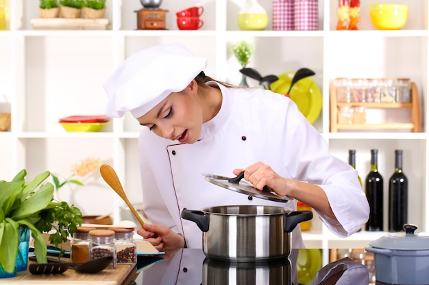 Mujer joven chef cocinando en la cocina