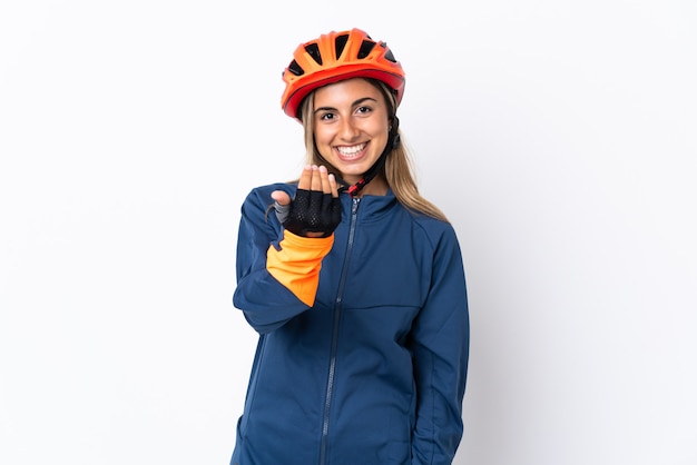 Mujer joven ciclista hispana aislada en la pared blanca que invita a venir con la mano. Feliz de que hayas venido