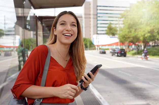 Mujer joven en la ciudad esperando un autobús o un taxi