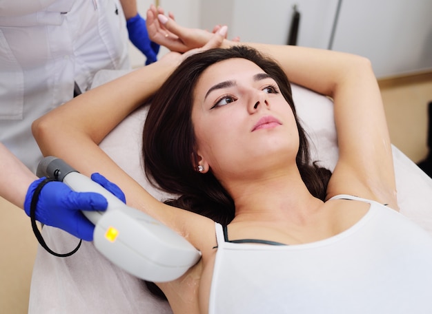 Una mujer joven en una clínica de cosmetología moderna.