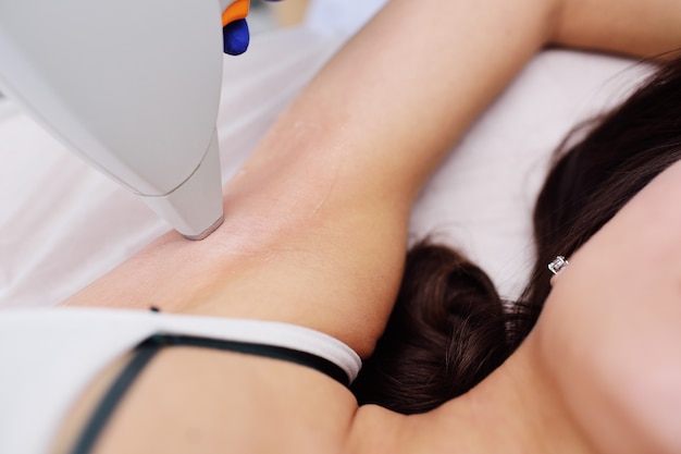 Una mujer joven en una clínica de cosmetología moderna.