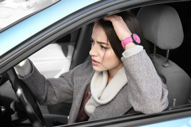 Mujer joven en coche durante el atasco de tráfico