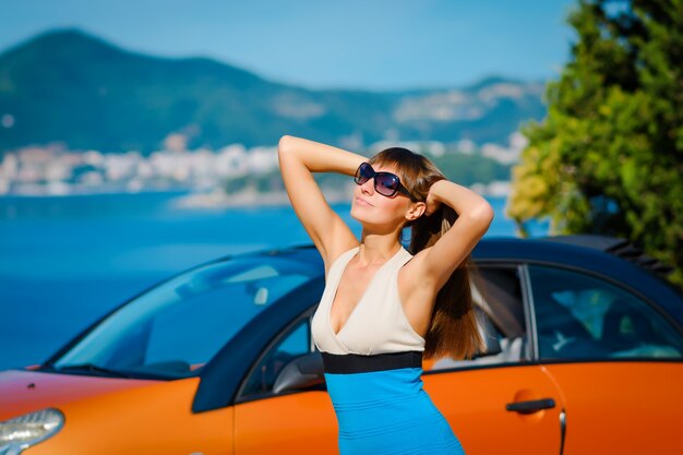 Mujer joven, con, coche, en, mar, lado