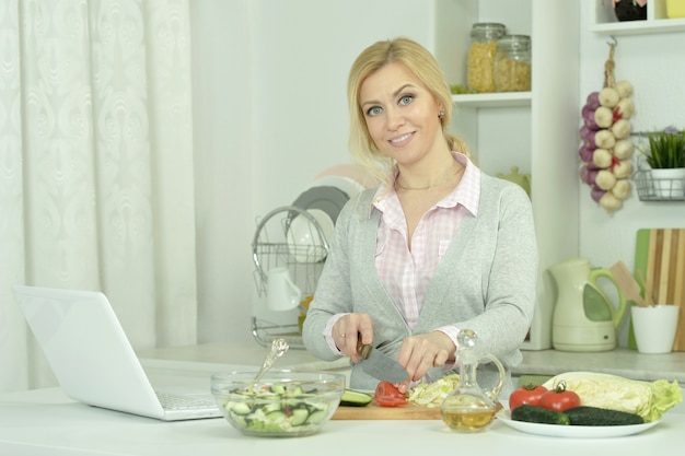 Mujer joven, cocina, en la cocina, con, computador portatil