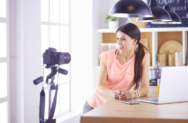 mujer joven, en, cocina, con, computadora de computadora portátil, mirar, recetas, sonriente, comida, blogger, concepto