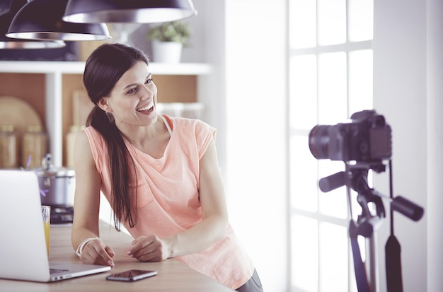 mujer joven, en, cocina, con, computadora de computadora portátil, mirar, recetas, sonriente, comida, blogger, concepto