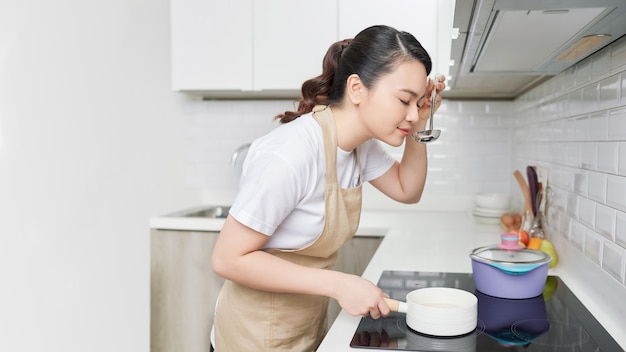 Mujer joven cocinando en la cocina. Comida sana.