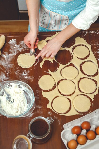 Mujer joven cocinando en la cocina, prepara la masa para hornear