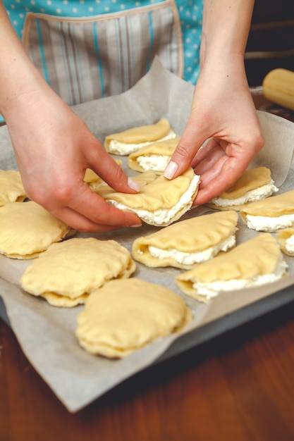 Mujer joven cocinando en la cocina, prepara los pasteles para hornear