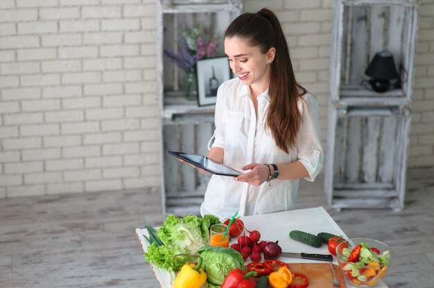 Mujer joven cocinando ensalada de verduras saludables