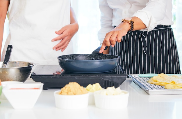 Mujer joven cocinar pastel dulce en la cocina