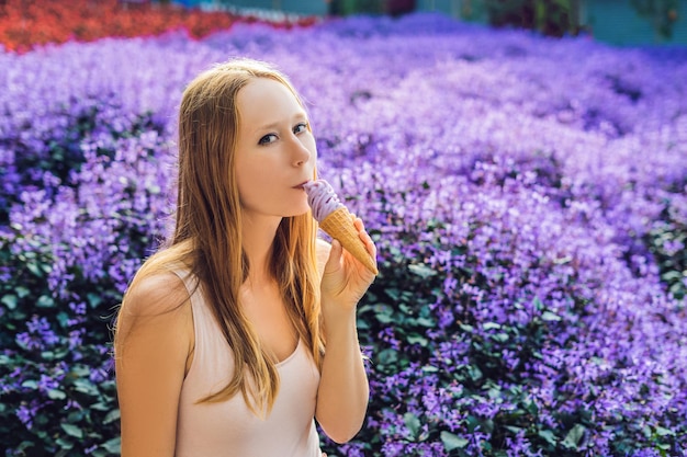 Mujer joven come helado de lavanda sobre un fondo de campo de lavanda