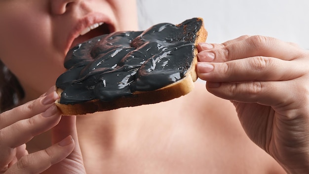 Una mujer joven come un sándwich relleno de tierra.