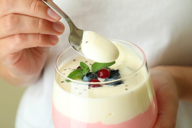 Foto mujer joven come yogur de bayas, cerrar