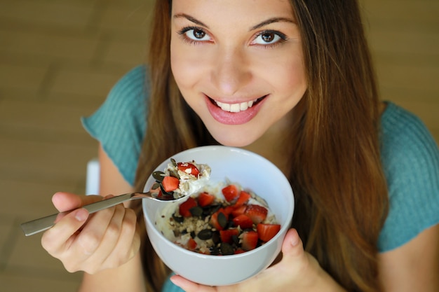 Mujer joven, comida, cereal, muesli, y, fruta