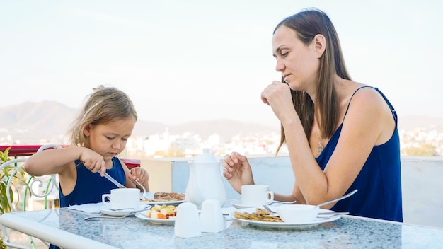 Foto mujer joven comiendo comida en la mesa