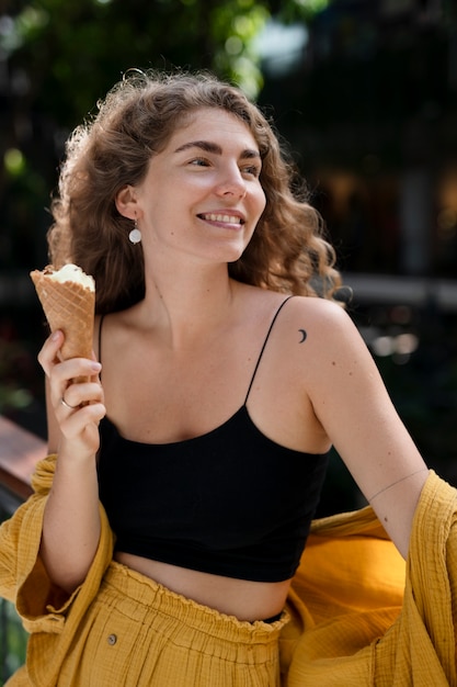 Foto mujer joven comiendo helado