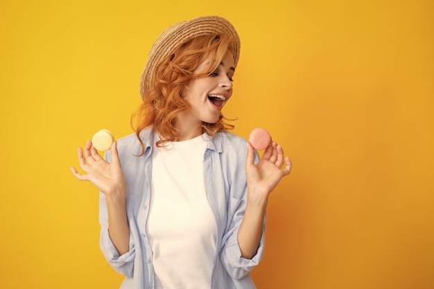 Mujer joven comiendo macarrones deliciosos sobre fondo amarillo