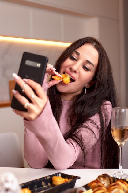 Mujer joven comiendo sushi comida asiática y fideos usando palillos de entrega para llevar