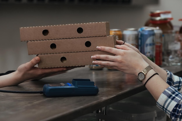 una mujer joven compra comida preparada en cajas de cartón con pedido anticipado en una cafetería