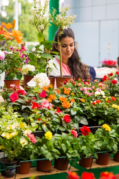 Mujer joven comprando flores