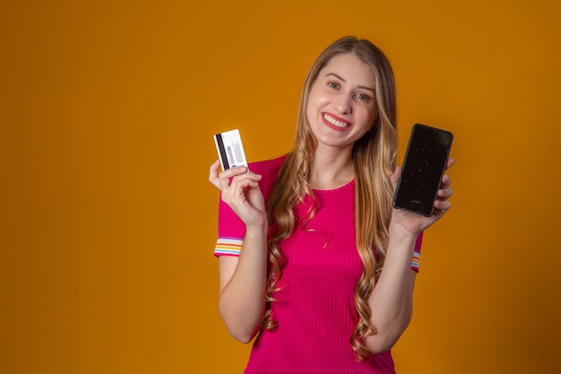 Mujer joven comprando online con tarjeta de crédito por teléfono