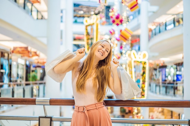 Mujer joven con compras en tienda de año nuevo Venta de Navidad viernes negro
