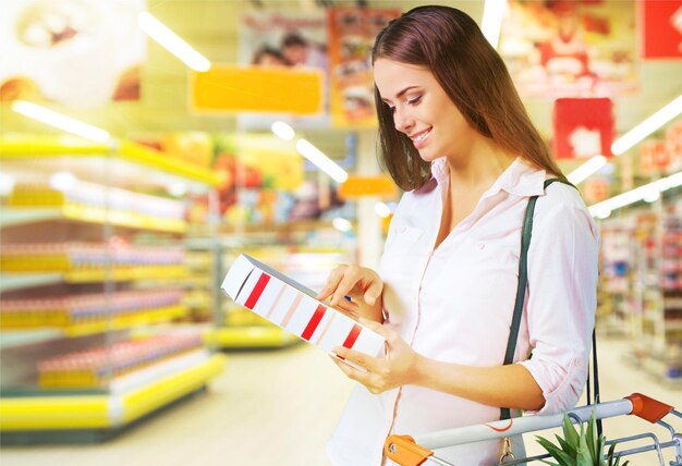 Foto mujer joven, compras, en, tienda de comestibles, con, carrito de compras