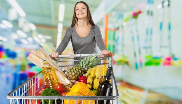 mujer joven, compras, en, tienda de comestibles, con, carrito de compras