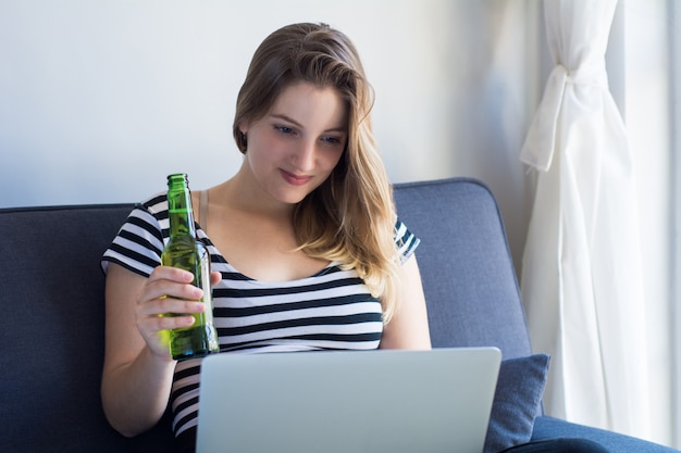 Mujer joven con una computadora portátil en casa