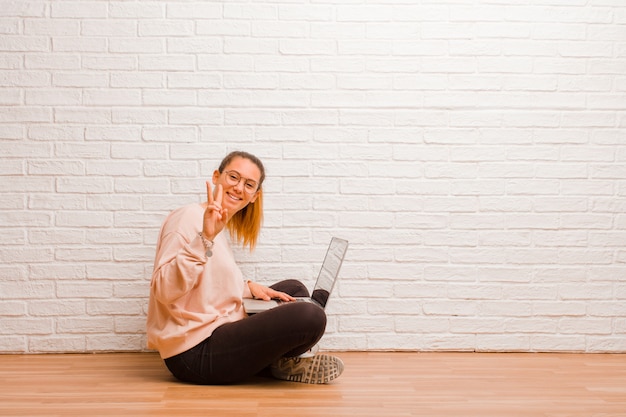 Foto mujer joven con una computadora portátil