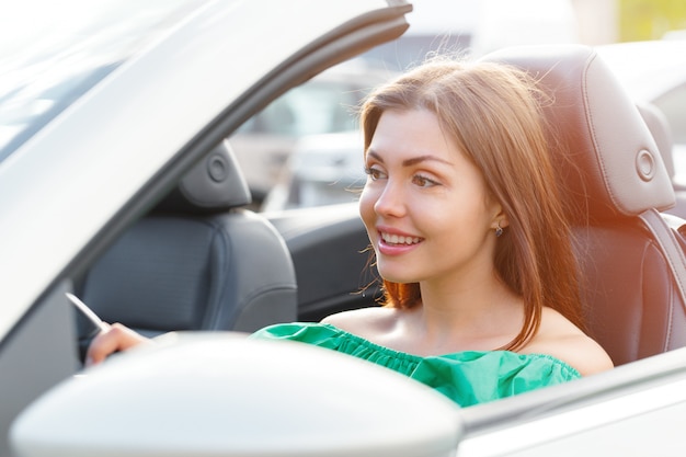 Mujer joven, conducir un coche, en la ciudad