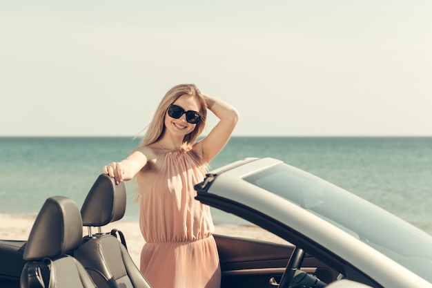 Mujer joven conducir un coche en la playa