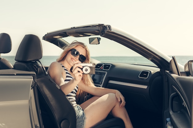 Mujer joven conducir un coche en la playa